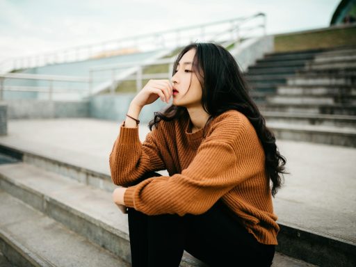 woman wearing brown sweater holding lips